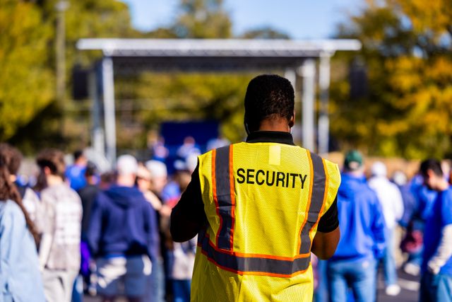 Security guard in front of a crowd of people